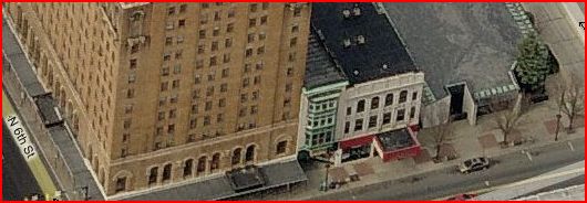 The Courthouse Deli is at the bottom floor of the white and green building in the center of this photo.